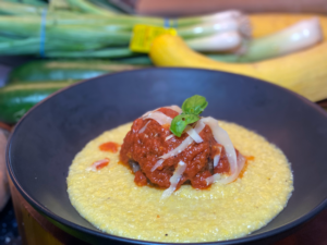 Giant meatball with tomato sauce in pool of soft polenta